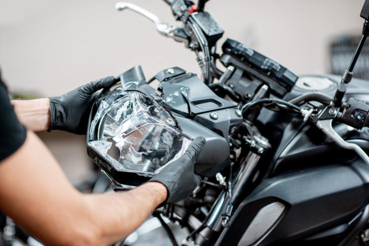 fanale moto rotto meccanico che l'aggiusta